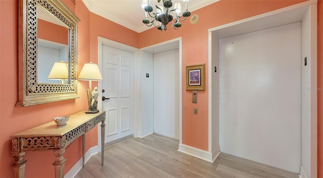 entrance foyer with light wood-type flooring, ornamental molding, elevator, and an inviting chandelier