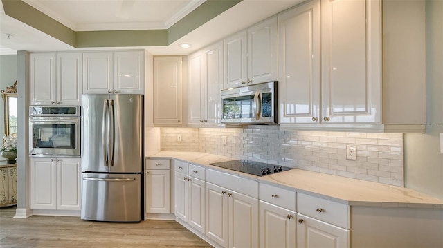 kitchen with white cabinets, appliances with stainless steel finishes, and decorative backsplash