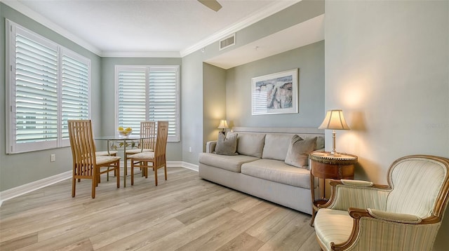 living room featuring crown molding and light hardwood / wood-style flooring