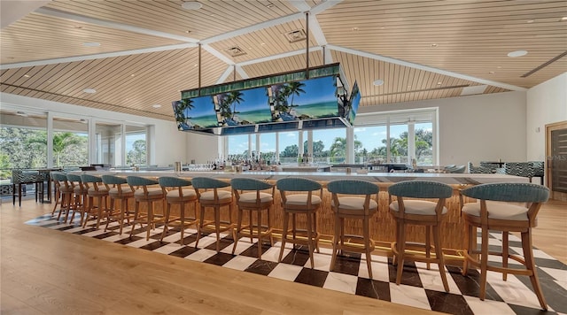 bar with light hardwood / wood-style floors, vaulted ceiling, and wooden ceiling