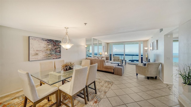 dining area with light tile patterned floors, a water view, and floor to ceiling windows