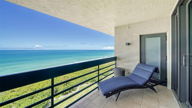 balcony with a water view and a beach view