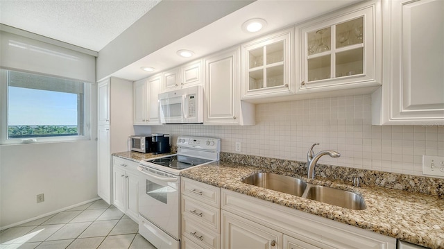 kitchen with sink, light stone counters, a textured ceiling, white appliances, and white cabinets