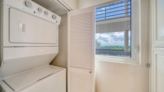 clothes washing area featuring stacked washing maching and dryer