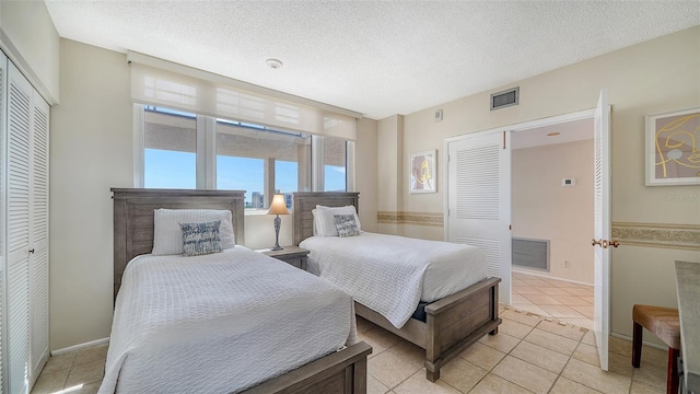 tiled bedroom featuring a textured ceiling