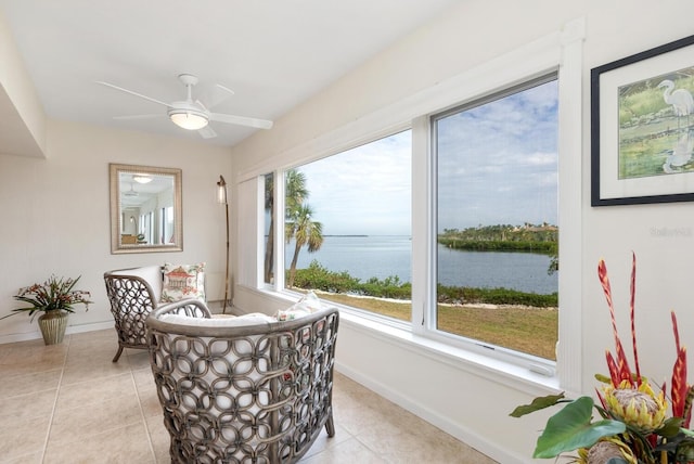 sunroom featuring a water view and ceiling fan