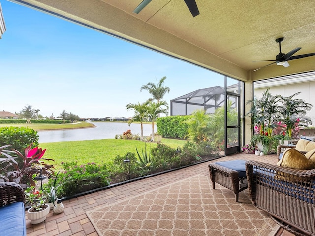 sunroom with a water view and a ceiling fan