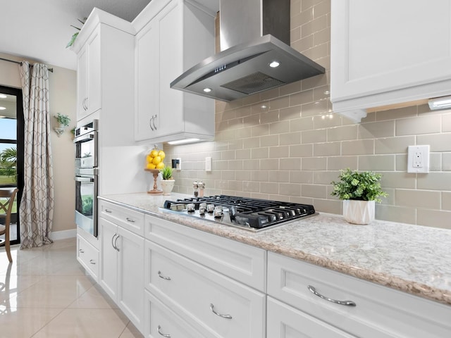 kitchen featuring extractor fan, light tile patterned flooring, stainless steel appliances, white cabinets, and backsplash