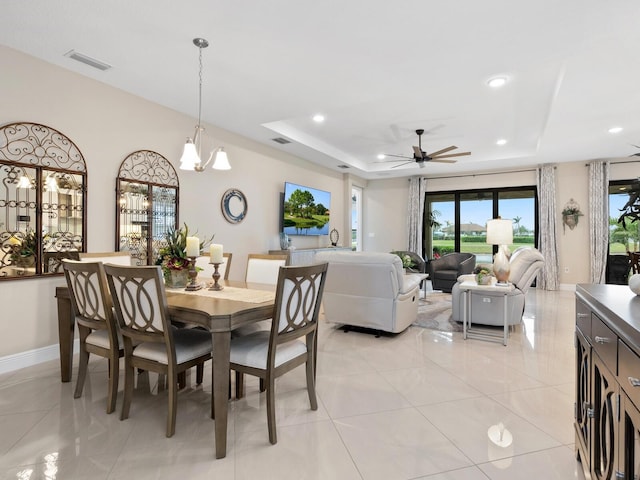 dining area with a tray ceiling, recessed lighting, visible vents, and baseboards