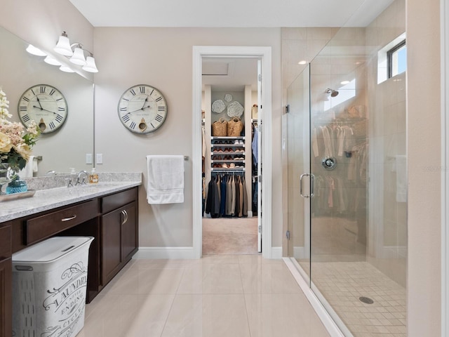 bathroom featuring a stall shower, baseboards, tile patterned floors, a spacious closet, and vanity