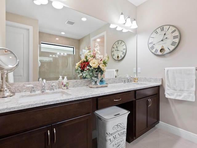 full bath with a stall shower, baseboards, visible vents, and a sink