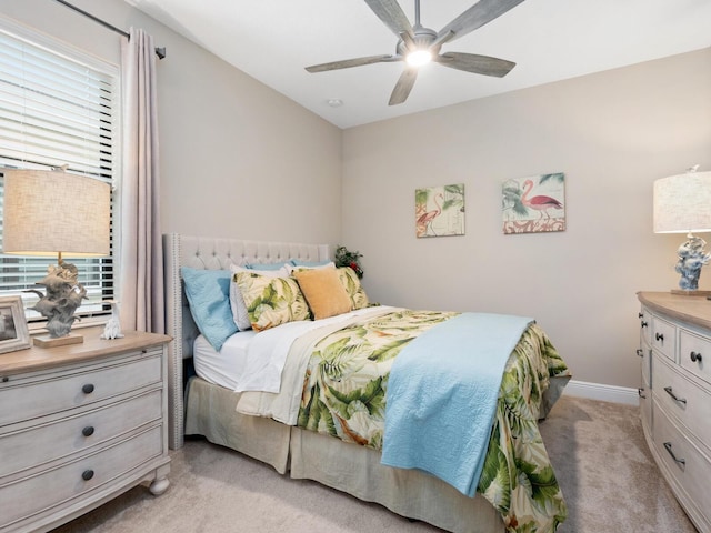 bedroom featuring ceiling fan, baseboards, and light colored carpet