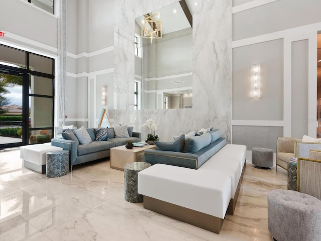 living room with marble finish floor and a high ceiling