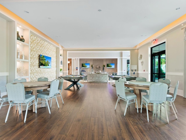 dining room featuring dark wood-style floors, built in shelves, a wainscoted wall, and french doors