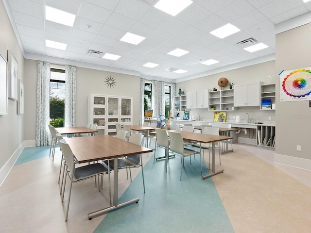 dining area with visible vents, a drop ceiling, and baseboards