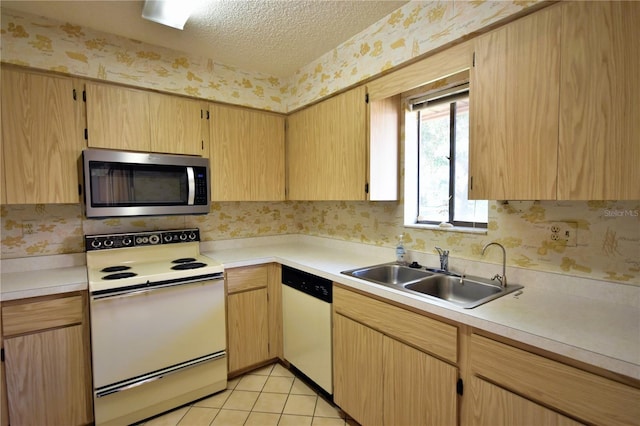 kitchen with sink, a textured ceiling, white appliances, light brown cabinetry, and light tile patterned floors