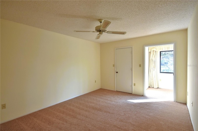 carpeted spare room with ceiling fan and a textured ceiling