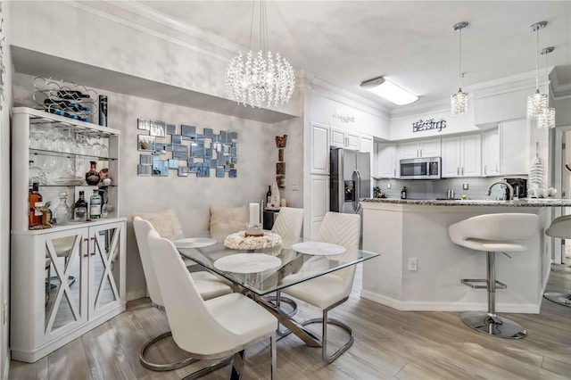 4106 Central Sarasota Pkwy Unit 1013, Sarasota, FL 34238 - dining area with crown molding, light wood finished floors, and a chandelier