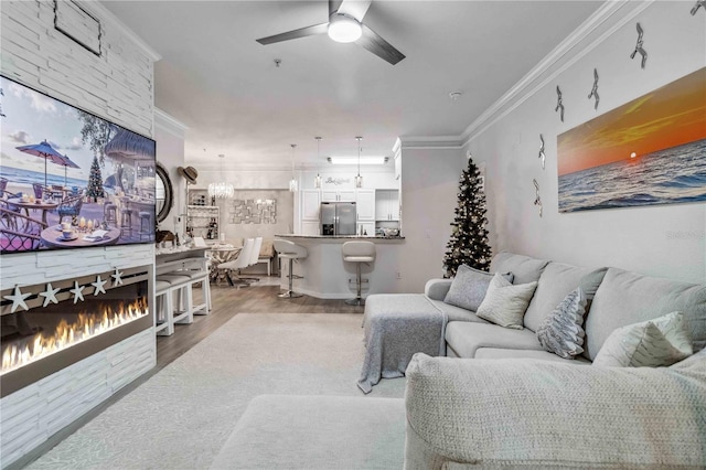 4106 Central Sarasota Pkwy Unit 1013, Sarasota, FL 34238 - living room with a large fireplace, ornamental molding, a ceiling fan, and wood finished floors