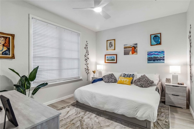 bedroom with a ceiling fan, baseboards, and light wood finished floors