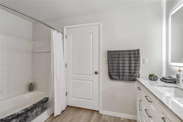 full bath featuring shower / bathtub combination with curtain, baseboards, wood finished floors, and vanity