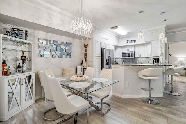 dining space with light wood-style floors and crown molding