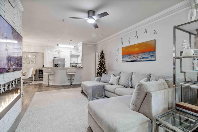 4106 Central Sarasota Pkwy Unit 1013, Sarasota, FL 34238 - living area with ornamental molding, a ceiling fan, a fireplace, and light wood-style floors
