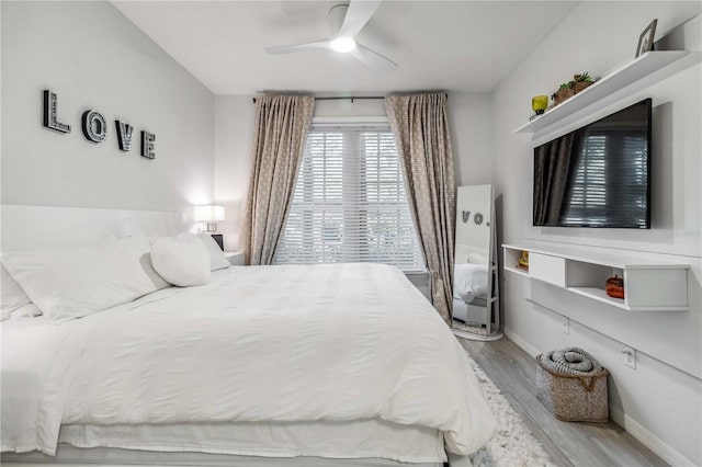 bedroom with wood finished floors, a ceiling fan, and baseboards