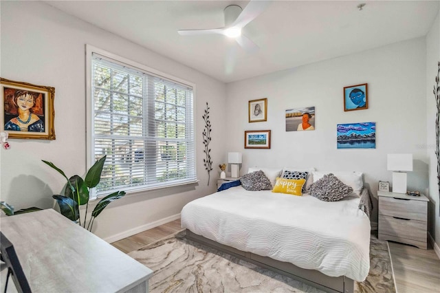 bedroom featuring baseboards, ceiling fan, and light wood-style floors