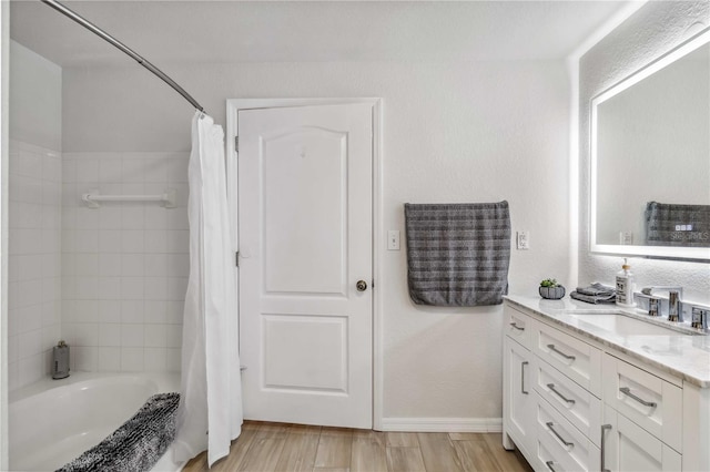 full bathroom featuring shower / tub combo with curtain, vanity, baseboards, and wood finished floors