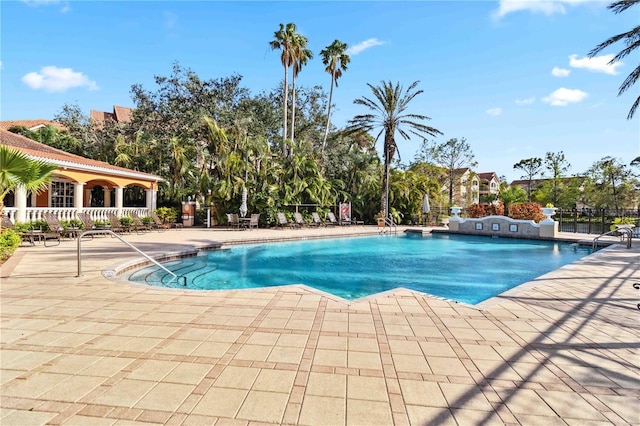 community pool featuring a patio and fence