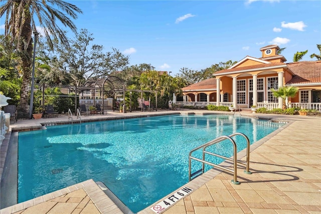 community pool with a patio and fence