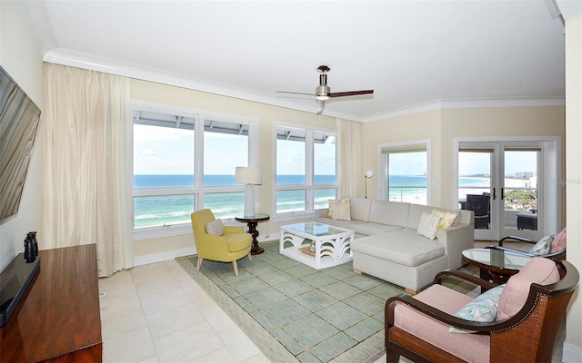 tiled living room featuring ceiling fan, crown molding, a water view, and a view of the beach