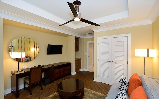 interior space featuring a raised ceiling, ceiling fan, dark hardwood / wood-style flooring, and crown molding