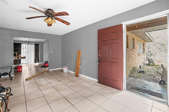 foyer entrance featuring ceiling fan with notable chandelier and light tile patterned flooring