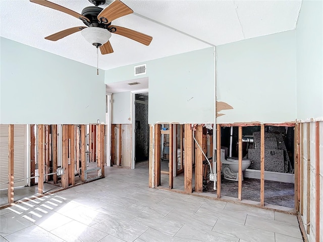 misc room with ceiling fan and a textured ceiling