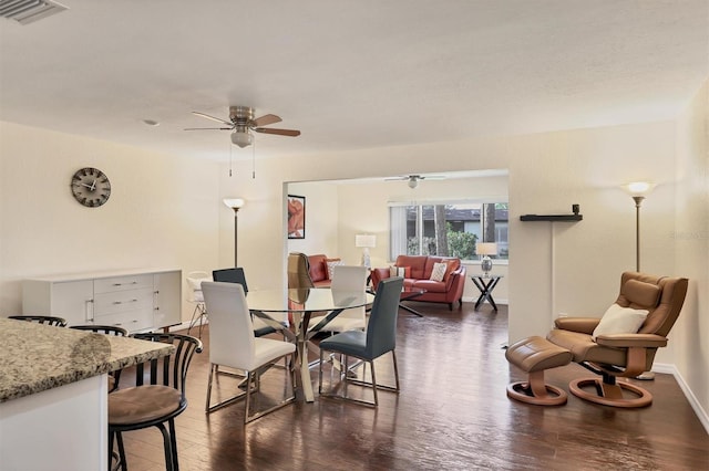 dining space with ceiling fan and dark wood-type flooring