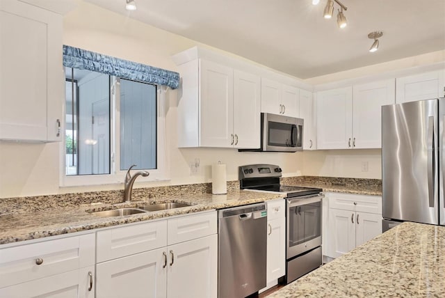 kitchen featuring light stone countertops, sink, white cabinets, and stainless steel appliances