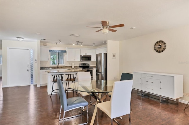 dining room with dark hardwood / wood-style flooring and ceiling fan