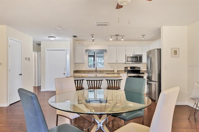 dining area with ceiling fan and dark wood-type flooring