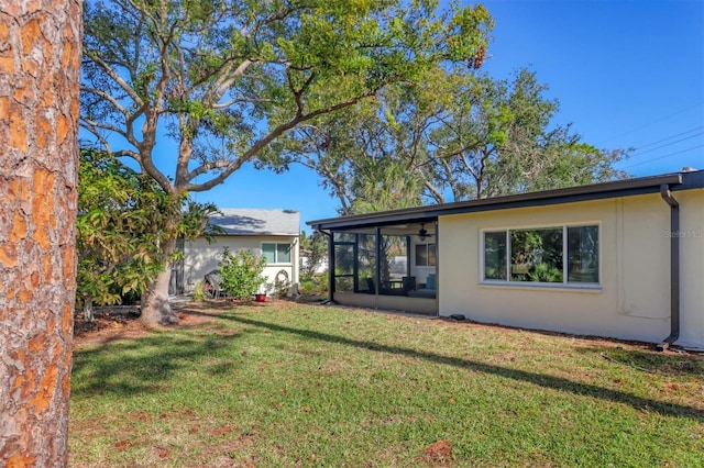 back of house with a sunroom and a yard