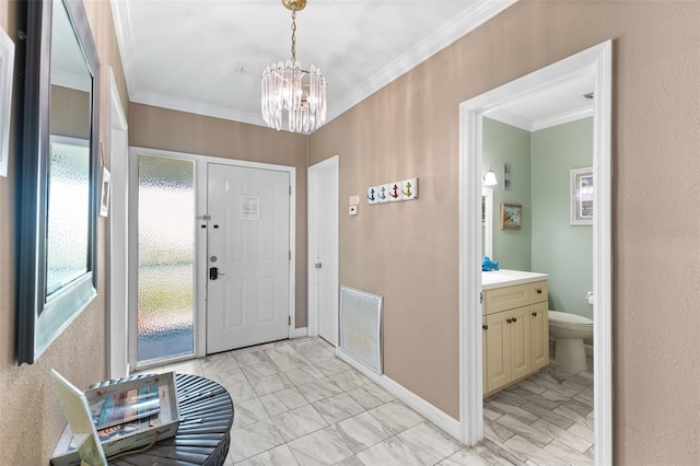 foyer entrance with a chandelier and ornamental molding