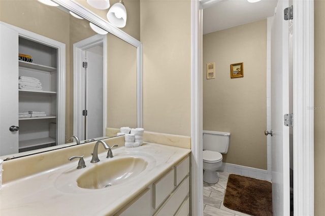 bathroom featuring built in features, vanity, and toilet