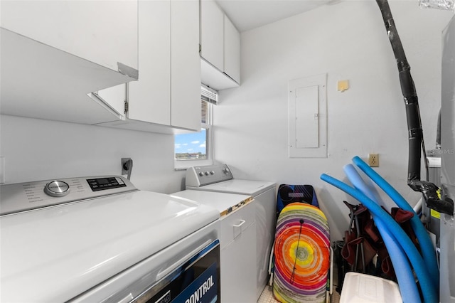 clothes washing area featuring cabinets, electric panel, and separate washer and dryer