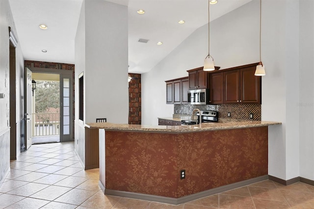 kitchen featuring tasteful backsplash, appliances with stainless steel finishes, kitchen peninsula, and light stone counters