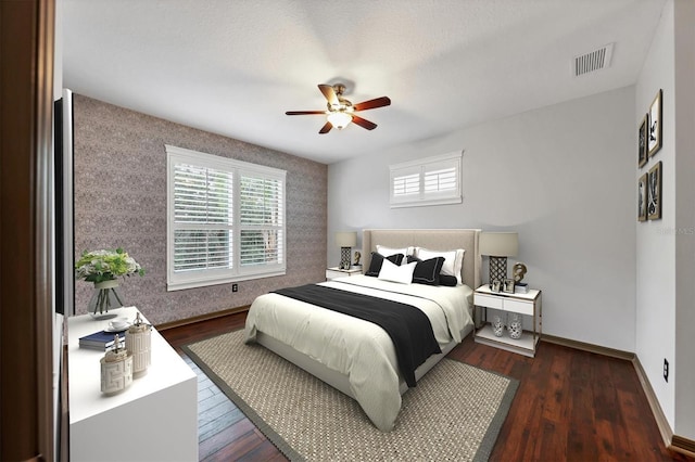 bedroom featuring multiple windows, dark hardwood / wood-style floors, and ceiling fan