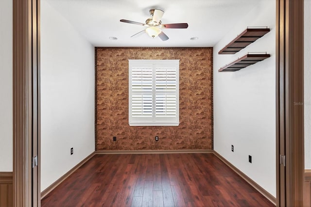 empty room with dark wood-type flooring and ceiling fan