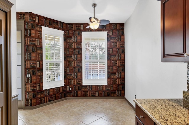 unfurnished dining area with light tile patterned floors and ceiling fan