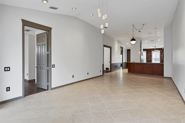 empty room featuring light tile patterned flooring and vaulted ceiling