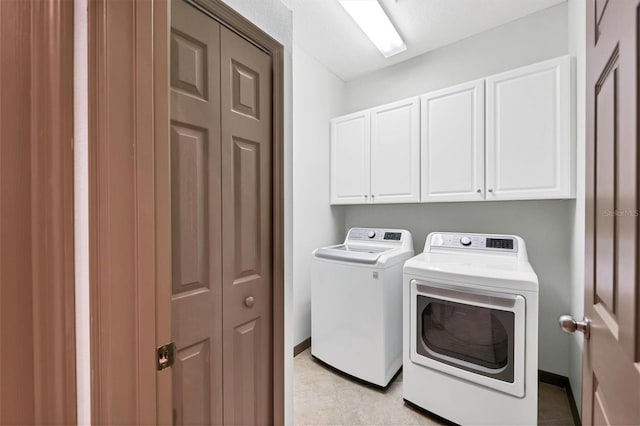 washroom with separate washer and dryer and cabinets